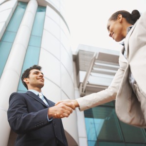 Low angle view of two business executives shaking hands